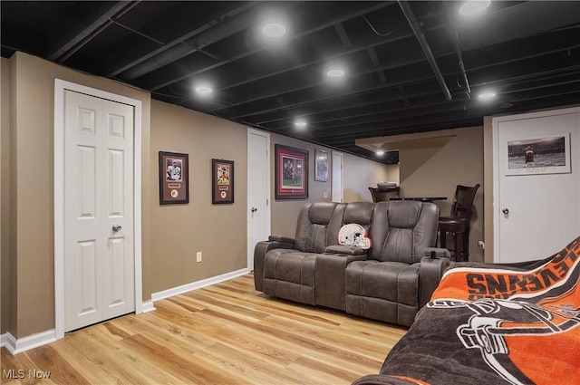 home theater featuring light wood-style flooring and baseboards