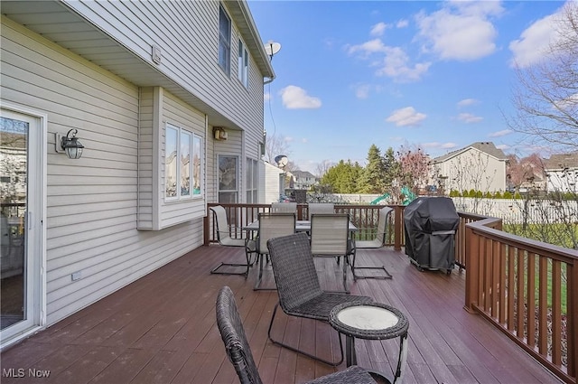 deck with outdoor dining area and a grill