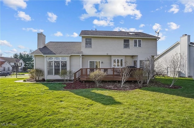 back of house featuring a wooden deck, a lawn, and a shingled roof