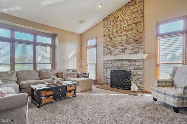 living area with carpet floors, a textured ceiling, visible vents, high vaulted ceiling, and a fireplace