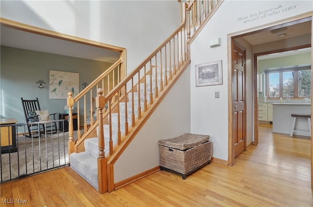 staircase with baseboards and wood finished floors
