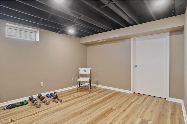 basement with baseboards and wood finished floors