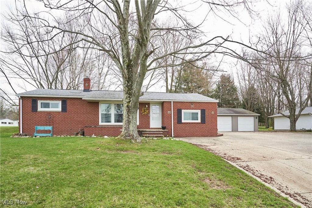 ranch-style house featuring brick siding, a front lawn, a chimney, and a garage