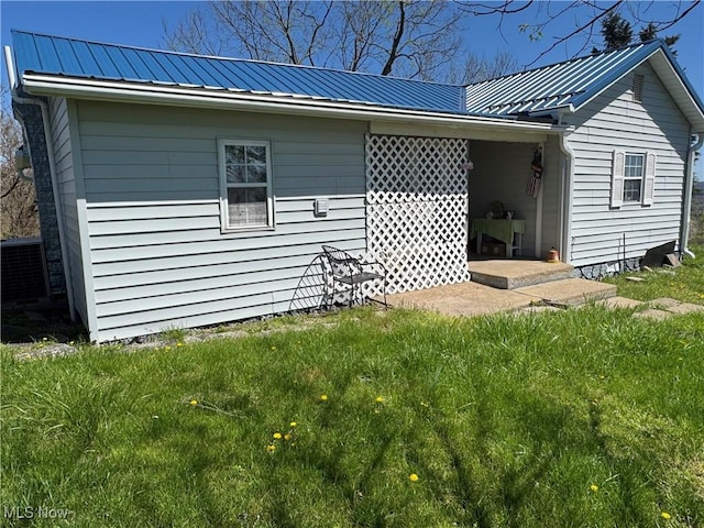 view of home's exterior with a yard and metal roof