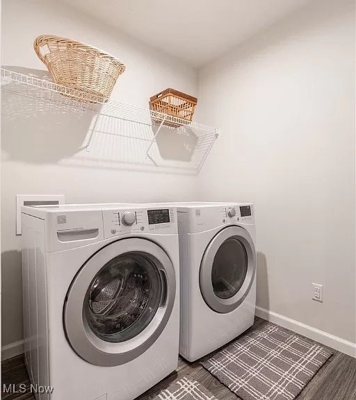 washroom featuring washing machine and clothes dryer, wood finished floors, baseboards, and laundry area
