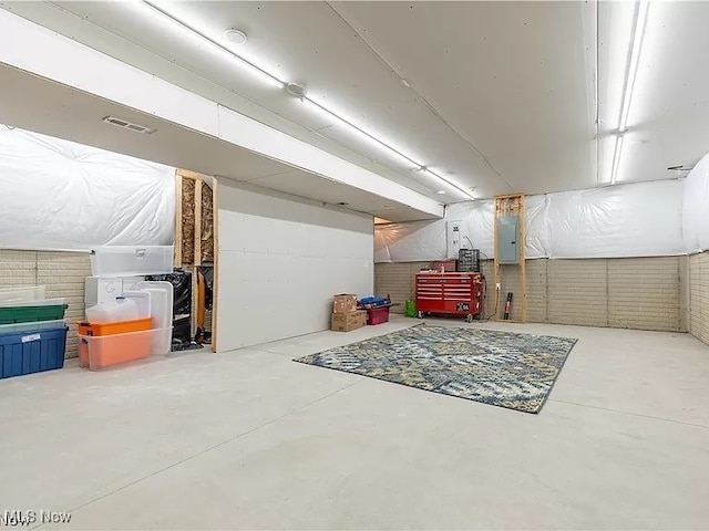 unfinished basement with electric panel and visible vents