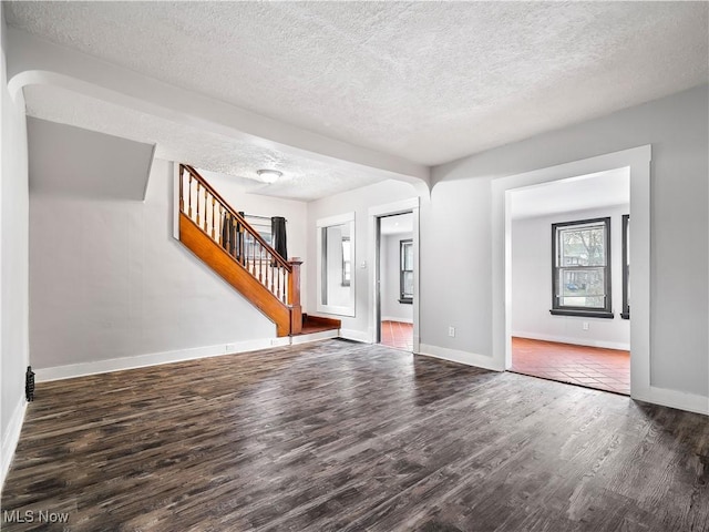 1821 Kenneth Ave, Cleveland, OH 44109 - unfurnished living room featuring wood finished floors, a textured ceiling, baseboards, and stairway