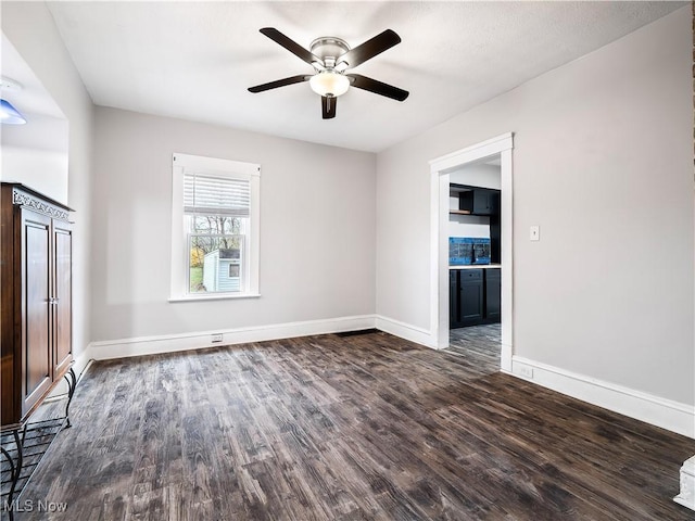 1821 Kenneth Ave, Cleveland, OH 44109 - spare room featuring dark wood finished floors, baseboards, and a ceiling fan