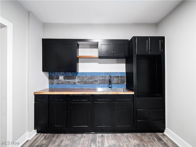 1821 Kenneth Ave, Cleveland, OH 44109 - kitchen featuring dark cabinetry, wood finished floors, baseboards, and a sink