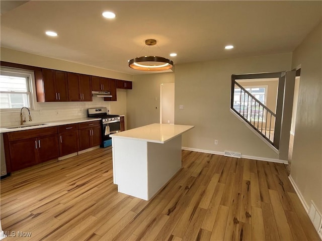 kitchen featuring a sink, light wood-style floors, light countertops, appliances with stainless steel finishes, and visible vents