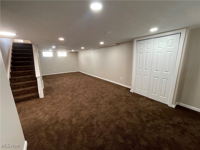 basement featuring dark colored carpet, baseboards, recessed lighting, and stairway