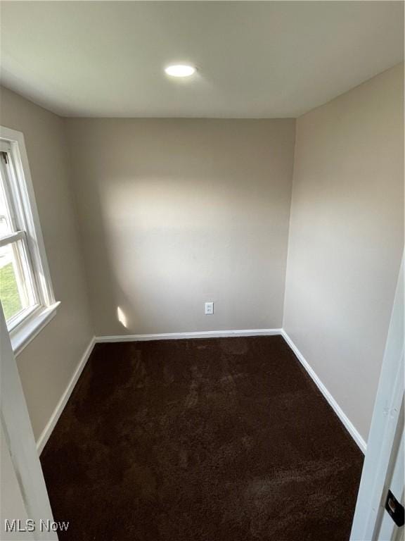 spare room featuring baseboards, dark carpet, and recessed lighting