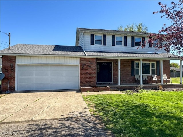 203 57th St, Vienna, WV 26105 - traditional-style house with driveway, a shingled roof, covered porch, an attached garage, and a front yard