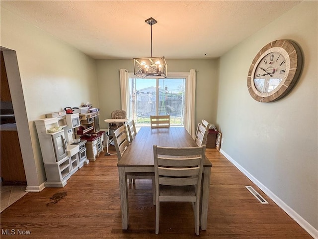 203 57th St, Vienna, WV 26105 - dining room featuring baseboards, visible vents, an inviting chandelier, and dark wood finished floors