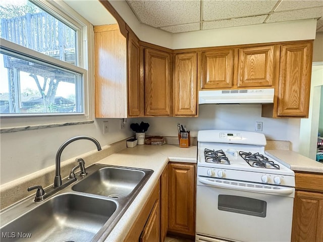 203 57th St, Vienna, WV 26105 - kitchen featuring brown cabinets, under cabinet range hood, a sink, and gas range gas stove