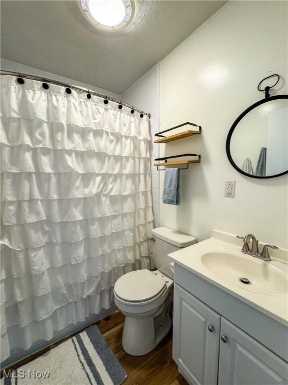 203 57th St, Vienna, WV 26105 - full bath featuring toilet, vanity, wood finished floors, and curtained shower