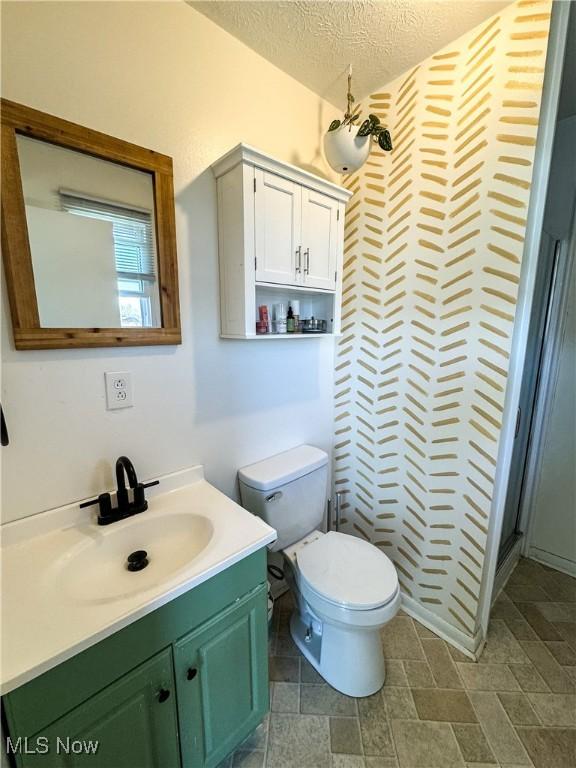 203 57th St, Vienna, WV 26105 - bathroom with a textured ceiling, toilet, vanity, and a shower