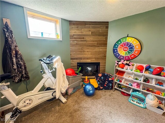 203 57th St, Vienna, WV 26105 - game room featuring carpet floors, a textured ceiling, wood walls, and a large fireplace
