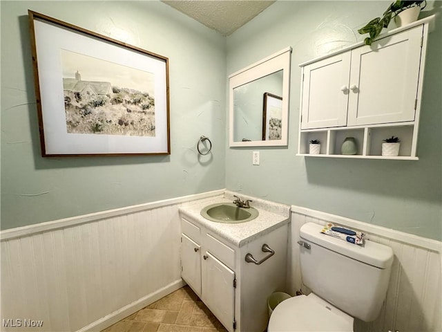 203 57th St, Vienna, WV 26105 - bathroom with vanity, toilet, a wainscoted wall, and a textured ceiling