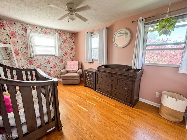 203 57th St, Vienna, WV 26105 - bedroom with light wood-type flooring, wallpapered walls, and a textured ceiling