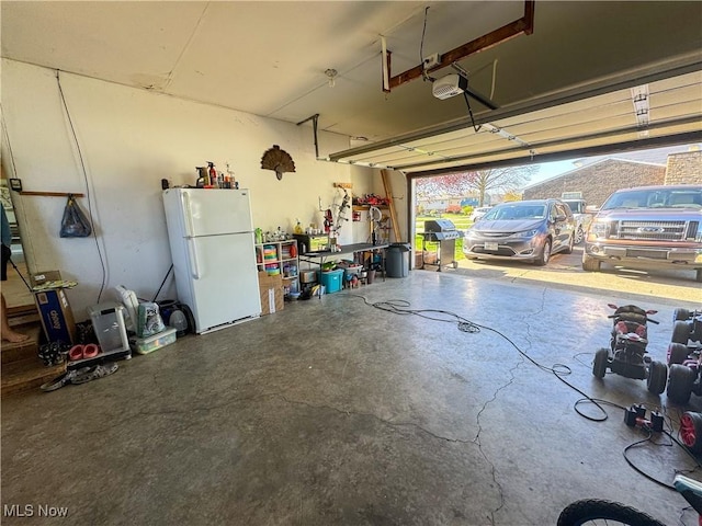 203 57th St, Vienna, WV 26105 - garage with a garage door opener and freestanding refrigerator
