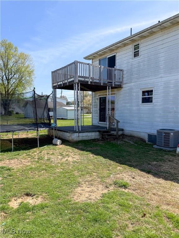 203 57th St, Vienna, WV 26105 - back of house featuring central air condition unit, a deck, a yard, and a trampoline