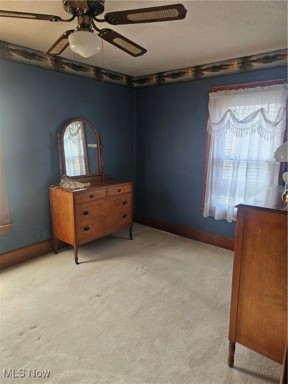 445 N 18th St, Sebring, OH 44672 - unfurnished bedroom featuring light carpet, baseboards, and ceiling fan