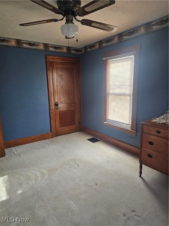 445 N 18th St, Sebring, OH 44672 - unfurnished bedroom featuring baseboards, carpet, a textured ceiling, and ceiling fan
