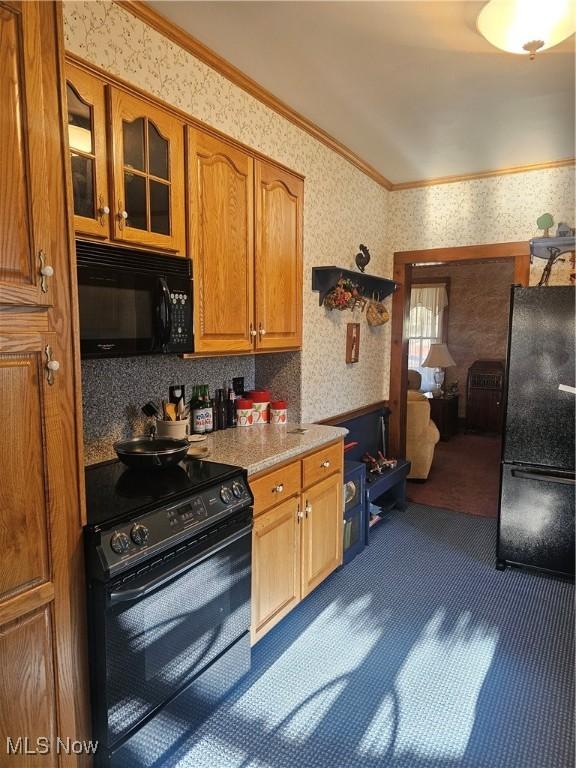 445 N 18th St, Sebring, OH 44672 - kitchen with wallpapered walls, brown cabinetry, ornamental molding, black appliances, and glass insert cabinets