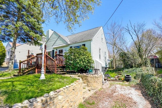 1865 9th St SW, Akron, OH 44314 - exterior space featuring a wooden deck, a yard, stairs, and a shingled roof