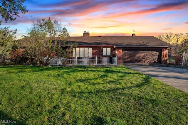 view of front of home with an attached garage, a chimney, aphalt driveway, and fence