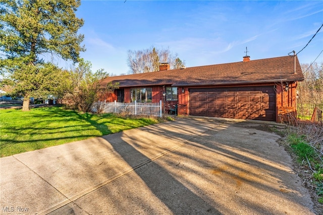 ranch-style house featuring a fenced front yard, concrete driveway, a chimney, a front lawn, and an attached garage