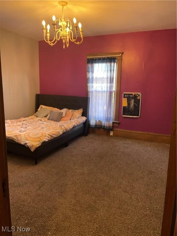 bedroom with an inviting chandelier and carpet