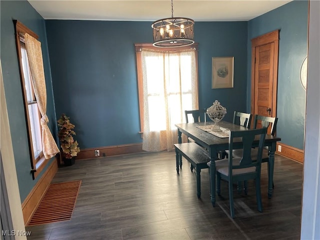 dining area featuring baseboards, wood finished floors, visible vents, and a chandelier