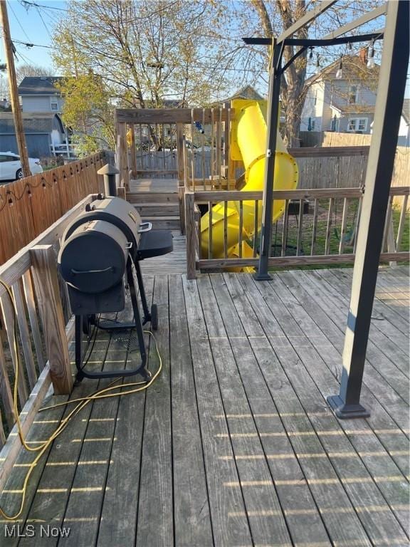 wooden terrace featuring fence private yard and a playground