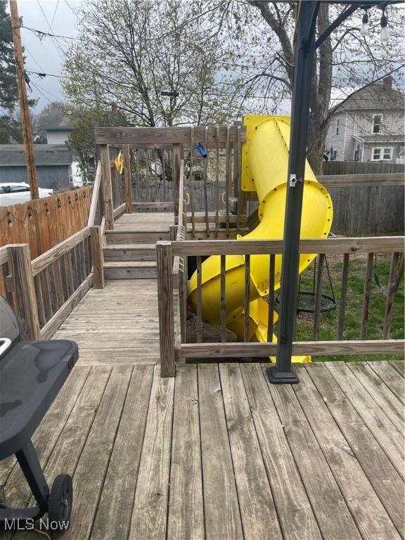 wooden deck with fence and a playground