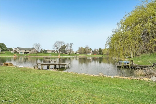view of dock with a water view and a yard
