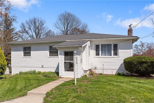 bungalow-style home with a front lawn, a chimney, and roof with shingles