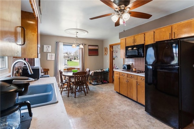 kitchen with decorative backsplash, light countertops, black appliances, and ceiling fan