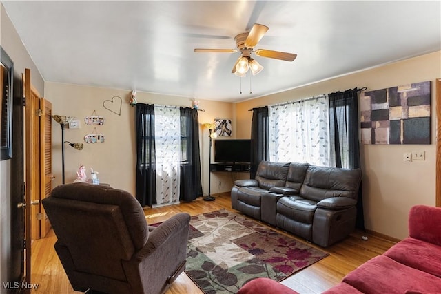 living area featuring ceiling fan, a wealth of natural light, and wood finished floors