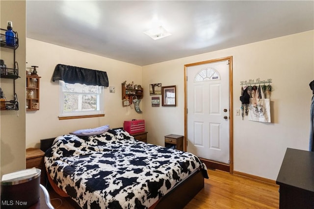 bedroom with baseboards and wood finished floors