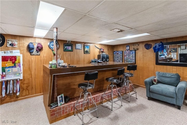 bar with wooden walls, a dry bar, visible vents, and carpet
