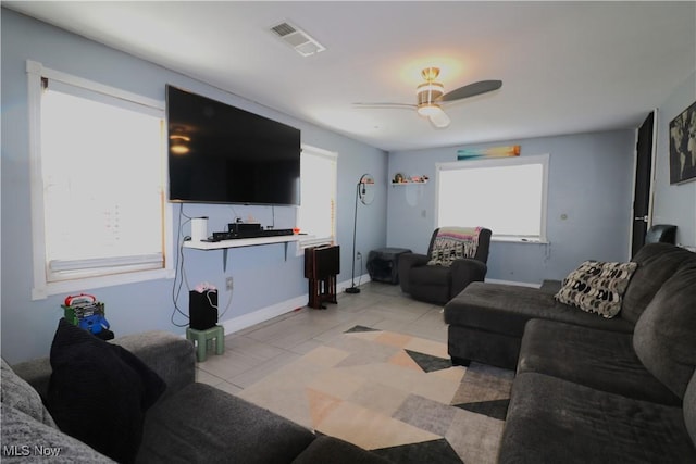 living area featuring visible vents, a ceiling fan, baseboards, and light tile patterned floors