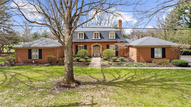 view of front facade with brick siding, a chimney, and a front yard