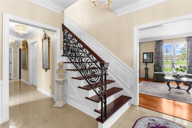 stairs featuring tile patterned flooring, a chandelier, and crown molding