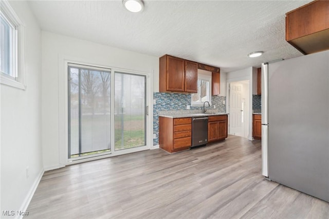 kitchen with light countertops, tasteful backsplash, appliances with stainless steel finishes, and plenty of natural light