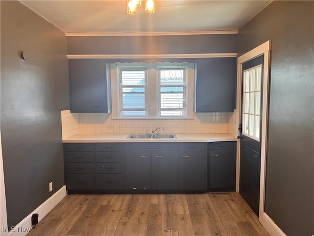 204 N Spring St, Loudonville, OH 44842 - kitchen with a sink, gray cabinets, backsplash, light wood-style floors, and ornamental molding