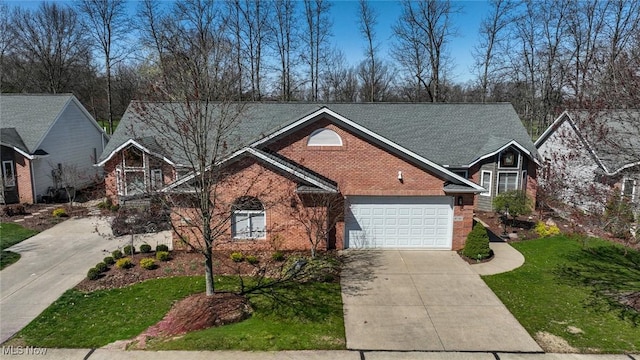 traditional-style home with brick siding, an attached garage, driveway, and a front yard