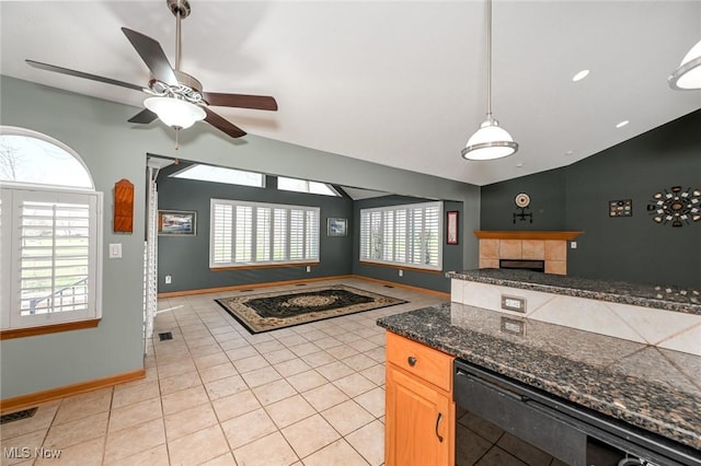 kitchen with open floor plan, ceiling fan, a fireplace, baseboards, and black dishwasher