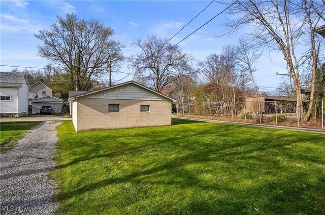 exterior space featuring a yard, concrete block siding, and fence
